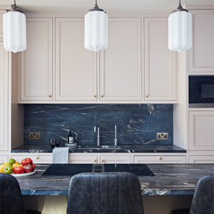 Design ideas for a contemporary galley eat-in kitchen in London with an integrated sink, recessed-panel cabinets, pink cabinets, marble benchtops, black splashback, marble splashback, with island and black benchtop.