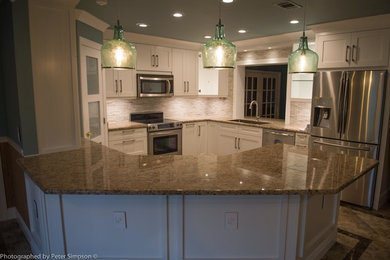 Mid-sized transitional u-shaped ceramic tile eat-in kitchen photo in Miami with an integrated sink, shaker cabinets, white cabinets, granite countertops, beige backsplash, stainless steel appliances, an island and glass sheet backsplash
