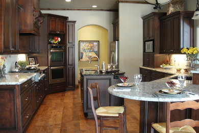 Eat-in kitchen - traditional u-shaped eat-in kitchen idea in Oklahoma City with raised-panel cabinets, dark wood cabinets, granite countertops and an island