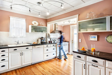 Eat-in kitchen - traditional l-shaped eat-in kitchen idea in Other with a drop-in sink, raised-panel cabinets, white cabinets, laminate countertops, white backsplash, subway tile backsplash and white appliances