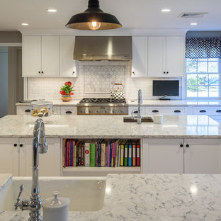 Idée de décoration pour une grand cuisine américaine tradition avec un évier de ferme, un placard à porte shaker, des portes de placard blanches, un plan de travail en quartz modifié, une crédence blanche, une crédence en carreau de porcelaine, un électroménager en acier inoxydable, un sol en bois brun et 2 îlots.