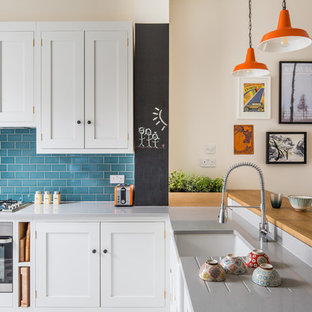 Foto de cocina en L, tradicional renovada, pequeña, con fregadero sobremueble, armarios estilo shaker, puertas de armario blancas, encimera de cuarzo compacto, salpicadero azul, salpicadero de azulejos tipo metro, electrodomésticos de acero inoxidable, suelo de baldosas de cerámica y suelo multicolor