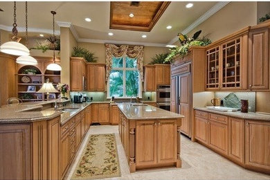 Photo of a traditional enclosed kitchen in Miami with raised-panel cabinets, light wood cabinets, granite worktops, stainless steel appliances, marble flooring and an island.
