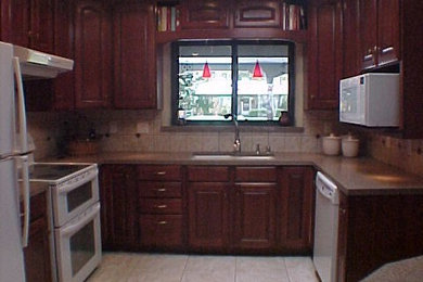 Mid-sized u-shaped ceramic tile kitchen photo in Albuquerque with an undermount sink, raised-panel cabinets, dark wood cabinets, quartz countertops, beige backsplash, ceramic backsplash, white appliances and an island