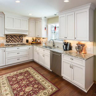 Inspiration for a large timeless l-shaped medium tone wood floor eat-in kitchen remodel in Milwaukee with an undermount sink, recessed-panel cabinets, white cabinets, granite countertops, white backsplash, subway tile backsplash and stainless steel appliances