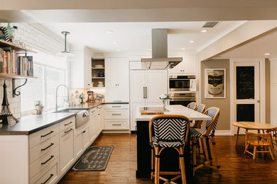 Mid-sized country l-shaped dark wood floor eat-in kitchen photo in Miami with a farmhouse sink, shaker cabinets, white cabinets, quartz countertops, white backsplash, ceramic backsplash, paneled appliances, an island and white countertops