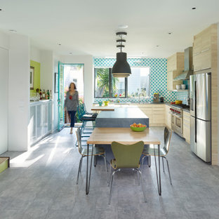 Contemporary eat-in kitchen designs - Eat-in kitchen - contemporary l-shaped gray floor eat-in kitchen idea in San Francisco with flat-panel cabinets, beige cabinets, metallic backsplash, stainless steel appliances, an island and gray countertops