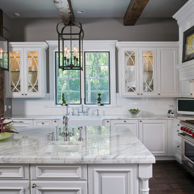 Example of a huge classic u-shaped dark wood floor open concept kitchen design in Chicago with a farmhouse sink, raised-panel cabinets, white cabinets, marble countertops, white backsplash, ceramic backsplash, paneled appliances and an island