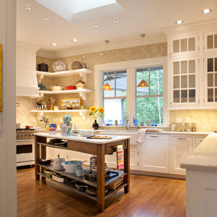 This is an example of a mid-sized traditional kitchen in Other with glass-front cabinets, terrazzo benchtops, a farmhouse sink, ceramic splashback, medium hardwood floors and white appliances.