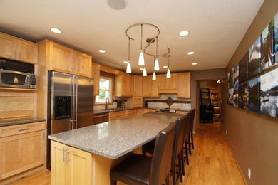 Eat-in kitchen - contemporary l-shaped light wood floor eat-in kitchen idea in Minneapolis with an undermount sink, shaker cabinets, light wood cabinets, quartz countertops, stone tile backsplash, stainless steel appliances and an island