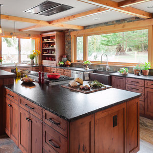 Design ideas for a mid-sized country galley separate kitchen in Seattle with a farmhouse sink, medium wood cabinets, granite benchtops, grey splashback, slate splashback, stainless steel appliances, porcelain floors, with island, grey floor and beaded inset cabinets.