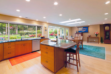 Eat-in kitchen - large contemporary bamboo floor eat-in kitchen idea in Portland with stainless steel appliances, stone slab backsplash, granite countertops, medium tone wood cabinets, flat-panel cabinets and an undermount sink