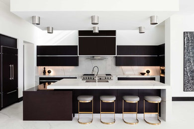 Contemporary u-shaped kitchen in Miami with a submerged sink, flat-panel cabinets, brown cabinets, white splashback, integrated appliances, an island, white floors and white worktops.