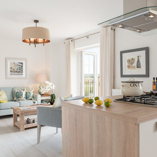 Ejemplo de cocina contemporánea, de tamaño medio, abierta, con armarios con paneles lisos, puertas de armario de madera clara, encimera de madera, suelo de madera clara y una isla