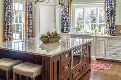 Large transitional l-shaped medium tone wood floor and brown floor eat-in kitchen photo in Charlotte with a double-bowl sink, flat-panel cabinets, white cabinets, quartzite countertops, beige backsplash, stone slab backsplash, paneled appliances, an island and beige countertops