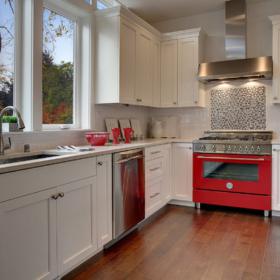 Example of a transitional open concept kitchen design in Seattle with recessed-panel cabinets, white cabinets, black backsplash, colored appliances and an undermount sink