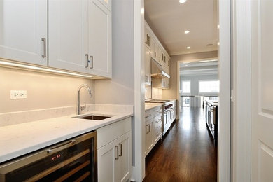 Example of a trendy kitchen design in Chicago with shaker cabinets, white cabinets and two islands