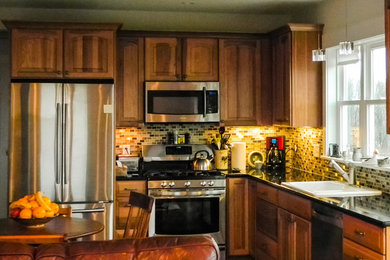 ニューヨークにあるお手頃価格の小さなトラディショナルスタイルのおしゃれなキッチン (シングルシンク、レイズドパネル扉のキャビネット、濃色木目調キャビネット、クオーツストーンカウンター、マルチカラーのキッチンパネル、ガラスタイルのキッチンパネル、シルバーの調理設備、濃色無垢フローリング) の写真