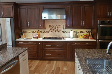 Eat-in kitchen - huge traditional medium tone wood floor and brown floor eat-in kitchen idea in New York with an undermount sink, raised-panel cabinets, dark wood cabinets, quartz countertops, beige backsplash, ceramic backsplash, stainless steel appliances and two islands