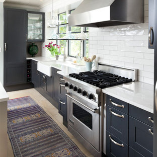 Transitional kitchen ideas - Example of a transitional kitchen design in Minneapolis with a farmhouse sink, shaker cabinets, blue cabinets, white backsplash, subway tile backsplash and stainless steel appliances