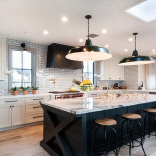 Foto de cocina en U, tradicional, con fregadero sobremueble, armarios estilo shaker, puertas de armario blancas, salpicadero blanco, salpicadero de azulejos tipo metro, suelo de madera en tonos medios y una isla
