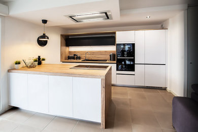 Aménagement d'une cuisine ouverte parallèle contemporaine de taille moyenne avec des portes de placard blanches, un plan de travail en stratifié et îlot.