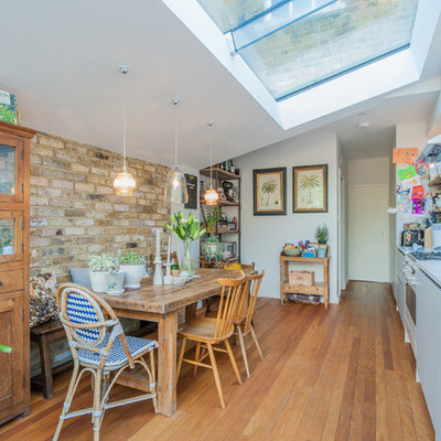 Eat-in kitchen - mid-sized transitional single-wall medium tone wood floor eat-in kitchen idea in London with an undermount sink, flat-panel cabinets, beige cabinets, quartzite countertops, colored appliances and no island