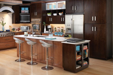 Kitchen - large contemporary l-shaped light wood floor and beige floor kitchen idea in Los Angeles with an undermount sink, flat-panel cabinets, dark wood cabinets, quartz countertops, white backsplash, stainless steel appliances and an island