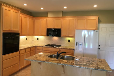 Mid-sized elegant l-shaped ceramic tile and beige floor kitchen photo in Sacramento with a double-bowl sink, recessed-panel cabinets, light wood cabinets, granite countertops, white backsplash, subway tile backsplash, black appliances and an island
