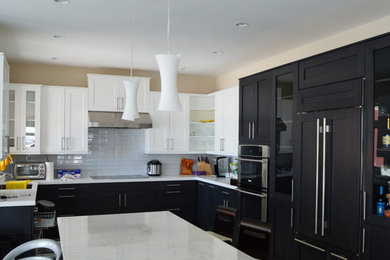 Kitchen - mid-sized contemporary u-shaped kitchen idea in Philadelphia with an undermount sink, shaker cabinets, black cabinets, white backsplash, subway tile backsplash and paneled appliances