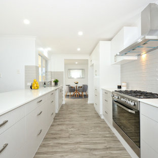 Design ideas for a large contemporary galley eat-in kitchen in Perth with white cabinets, granite benchtops, grey splashback, stainless steel appliances, vinyl floors, grey floor, white benchtop, flat-panel cabinets and a peninsula.