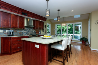 Example of a mid-sized transitional galley light wood floor eat-in kitchen design in Philadelphia with a single-bowl sink, shaker cabinets, dark wood cabinets, granite countertops, gray backsplash, stone tile backsplash, stainless steel appliances and an island