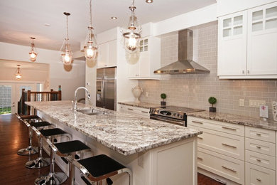 Einzeilige, Mittelgroße Klassische Wohnküche mit Doppelwaschbecken, weißen Schränken, Granit-Arbeitsplatte, Küchengeräten aus Edelstahl, braunem Holzboden und Kücheninsel in Calgary