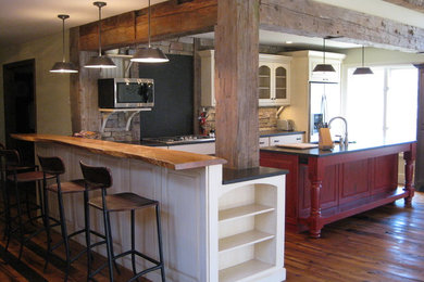 Foto på ett stort vintage kök, med granitbänkskiva, stänkskydd i stenkakel, rostfria vitvaror, mellanmörkt trägolv, en köksö, en dubbel diskho, släta luckor, vita skåp och svart stänkskydd