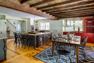 Photo of a traditional open plan kitchen in Boston with raised-panel cabinets, light hardwood flooring and an island.