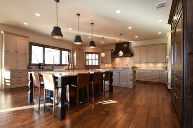 Large transitional u-shaped medium tone wood floor open concept kitchen photo in Chicago with a farmhouse sink, recessed-panel cabinets, gray cabinets, granite countertops, gray backsplash, cement tile backsplash, paneled appliances and two islands