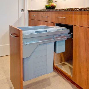 Cette photo montre une cuisine parallèle tendance fermée avec un évier encastré, un placard à porte plane, des portes de placard en bois clair, un plan de travail en verre recyclé, une crédence blanche, une crédence en carreau de porcelaine, un électroménager en acier inoxydable, un sol en carrelage de porcelaine et aucun îlot.
