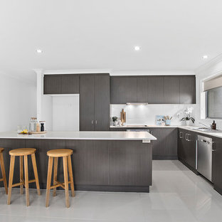 Inspiration for a beach style l-shaped kitchen in Other with a drop-in sink, flat-panel cabinets, grey cabinets, white splashback, stainless steel appliances, with island, grey floor and white benchtop.