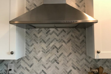 Mid-sized transitional l-shaped porcelain tile and gray floor eat-in kitchen photo in New York with a farmhouse sink, shaker cabinets, white cabinets, concrete countertops, gray backsplash, porcelain backsplash, stainless steel appliances, no island and gray countertops