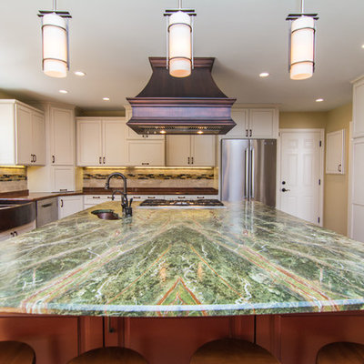 Example of a large eclectic medium tone wood floor eat-in kitchen design in DC Metro with a farmhouse sink, flat-panel cabinets, white cabinets, granite countertops, beige backsplash, stone tile backsplash, stainless steel appliances and an island