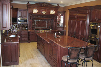 На фото: п-образная кухня в классическом стиле с обеденным столом, врезной мойкой, темными деревянными фасадами, гранитной столешницей, разноцветным фартуком и техникой из нержавеющей стали