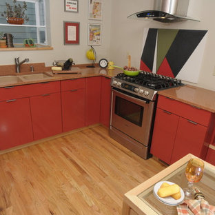 Immagine di una cucina moderna di medie dimensioni con lavello sottopiano, ante lisce, ante arancioni, top in granito, paraspruzzi arancione, paraspruzzi in lastra di pietra, elettrodomestici in acciaio inossidabile, parquet chiaro e penisola