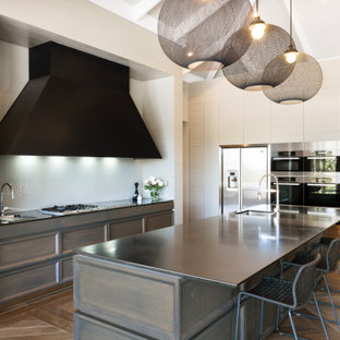 Design ideas for a large contemporary l-shaped kitchen in Melbourne with recessed-panel cabinets, quartz benchtops, white splashback, glass sheet splashback, stainless steel appliances, medium hardwood floors, with island, brown floor, vaulted, an undermount sink and dark wood cabinets.
