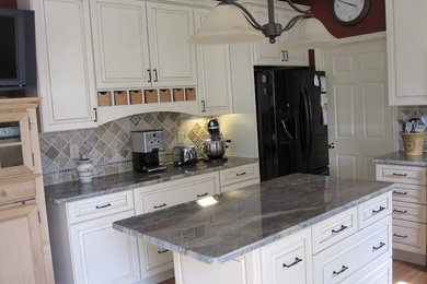 Example of a small classic u-shaped light wood floor eat-in kitchen design in Other with a double-bowl sink, flat-panel cabinets, white cabinets, granite countertops, brown backsplash, ceramic backsplash, colored appliances and an island
