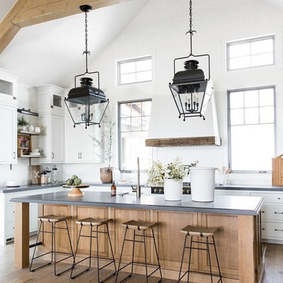Large cottage u-shaped dark wood floor and brown floor kitchen photo in Salt Lake City with white cabinets, white backsplash, black appliances, an island, gray countertops and shaker cabinets