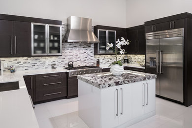 Example of a mid-sized transitional u-shaped porcelain tile and white floor enclosed kitchen design in Miami with an undermount sink, flat-panel cabinets, black cabinets, quartz countertops, white backsplash, matchstick tile backsplash, stainless steel appliances and an island