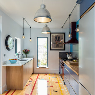 This is an example of a small contemporary galley kitchen/diner in Surrey with an integrated sink, flat-panel cabinets, medium wood cabinets, quartz worktops, grey splashback, coloured appliances, medium hardwood flooring and multi-coloured floors.