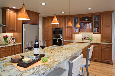 Example of a large transitional u-shaped medium tone wood floor open concept kitchen design in Seattle with an undermount sink, raised-panel cabinets, dark wood cabinets, granite countertops, beige backsplash, stainless steel appliances and an island