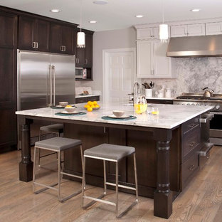 Inspiration for a mid-sized timeless u-shaped medium tone wood floor kitchen remodel in Seattle with an undermount sink, shaker cabinets, dark wood cabinets, marble countertops, white backsplash, stone slab backsplash, stainless steel appliances and an island