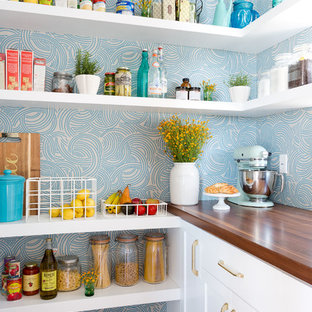 Photo of a beach style kitchen pantry in Los Angeles with shaker cabinets, white cabinets, blue splashback and dark hardwood floors.